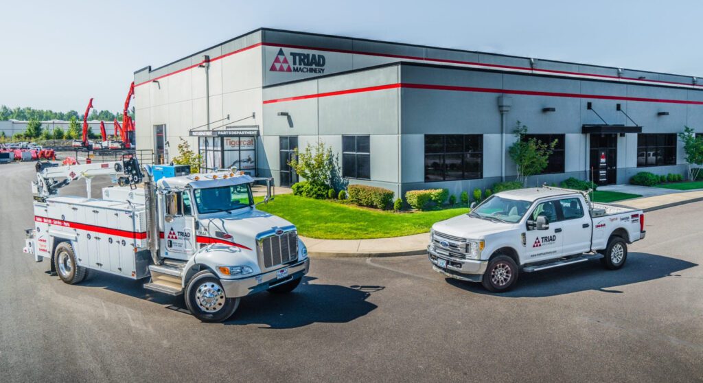 Exterior shot of a Triad Machinery location with a service truck and pickup our front.