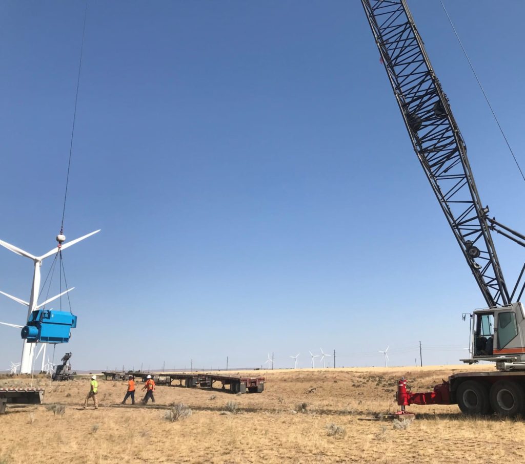Crane lifting wind turbine blade on a wind farm | Triad Machinery